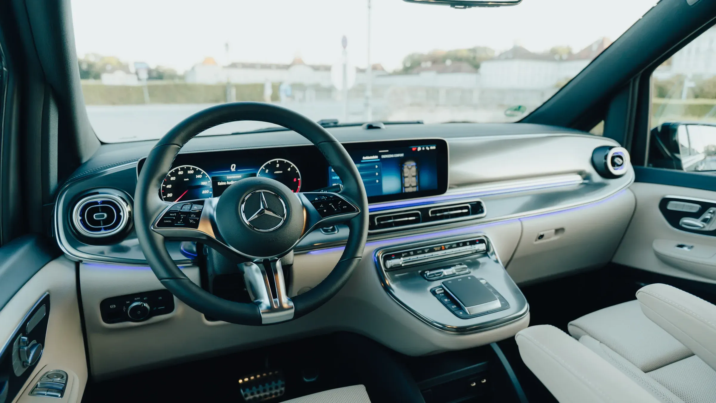 Cockpit der V-Klasse Premium mit MBUX-Widescreen, Lederlenkrad und blauer Ambientebeleuchtung
